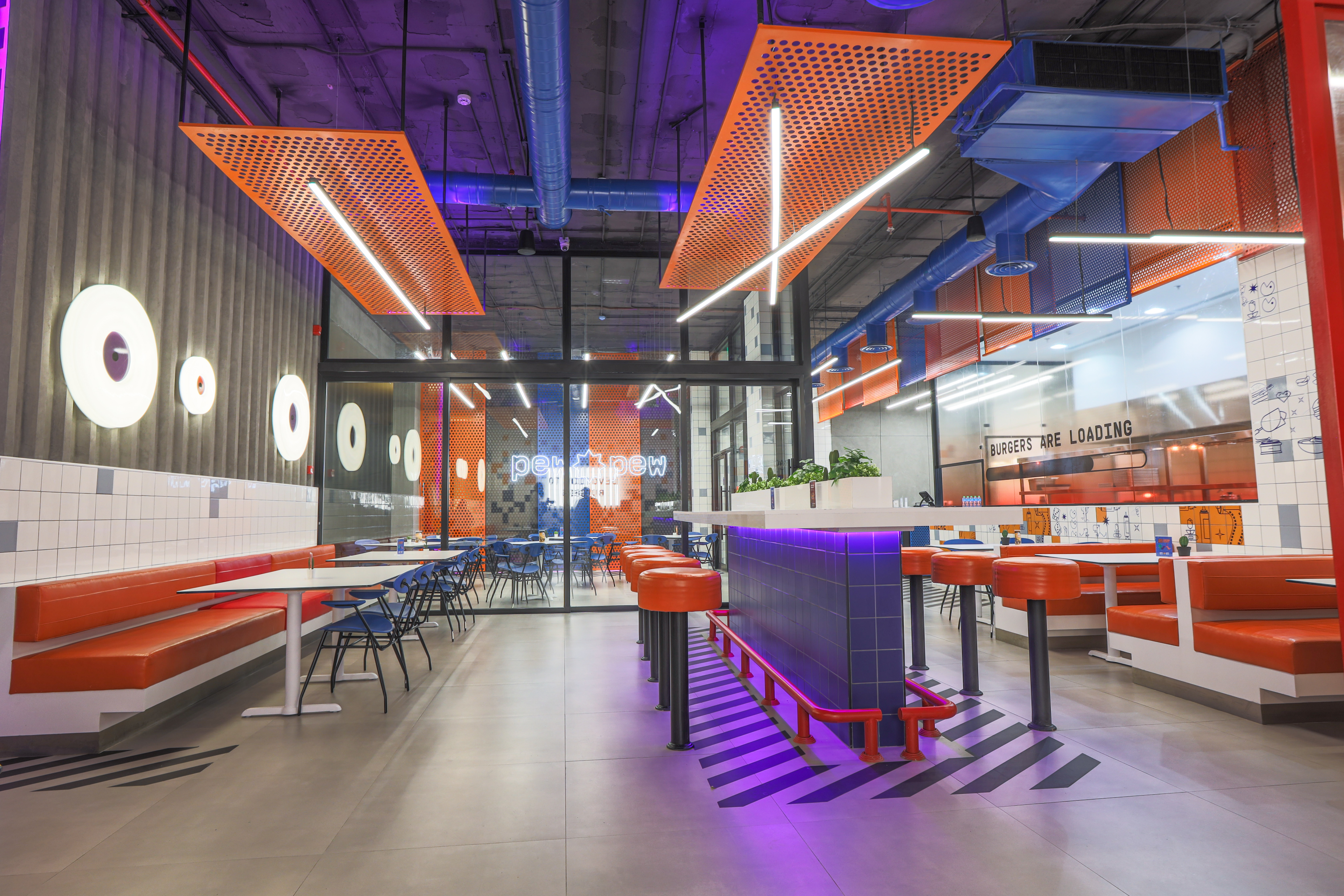 Pew Pew — arcade zone with retro cabinet, striped floor, and orange booths